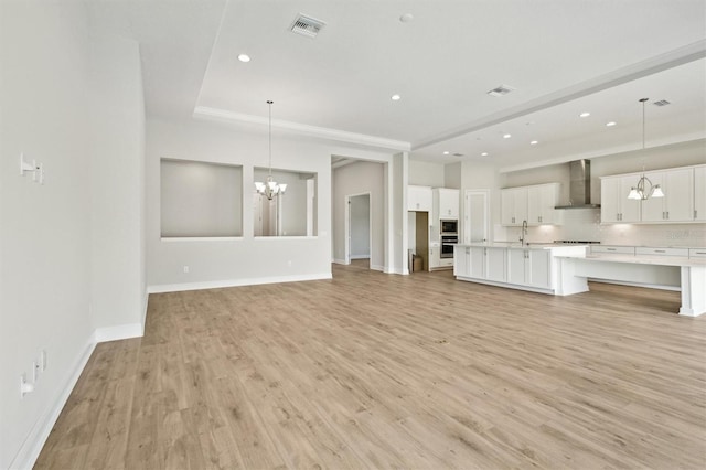 unfurnished living room with recessed lighting, visible vents, baseboards, light wood finished floors, and an inviting chandelier