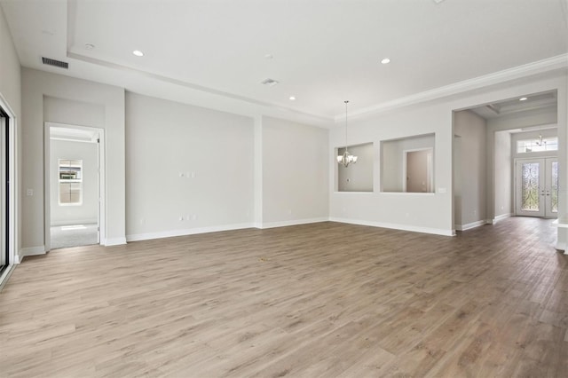 unfurnished living room with a chandelier, baseboards, visible vents, and light wood-style floors