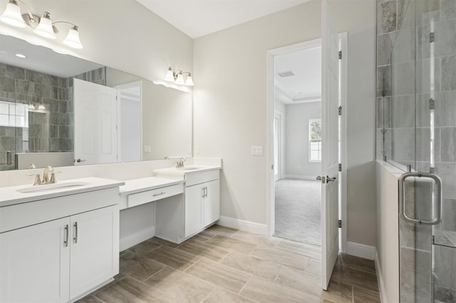 full bath featuring a sink, a shower stall, baseboards, and double vanity