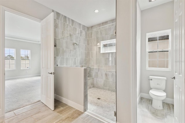 full bath featuring toilet, a shower stall, and baseboards