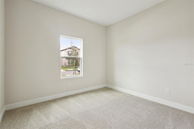 empty room featuring carpet flooring and baseboards