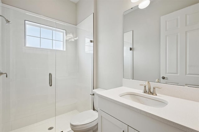 full bath with a stall shower, vanity, and toilet