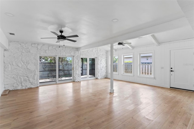 unfurnished living room featuring light hardwood / wood-style flooring, beamed ceiling, ceiling fan, and plenty of natural light