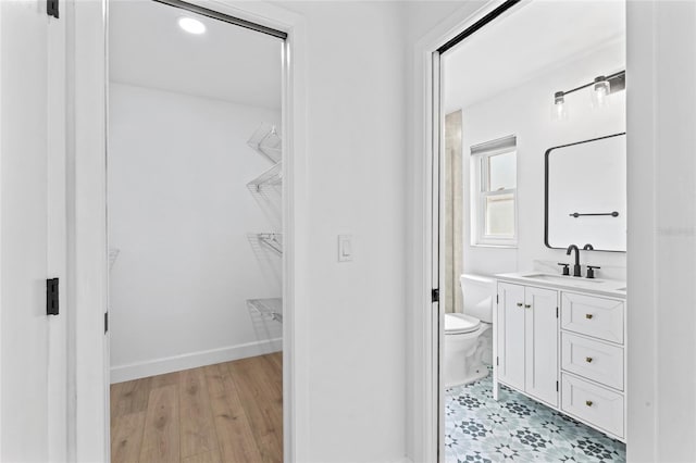 bathroom with wood-type flooring, toilet, and vanity