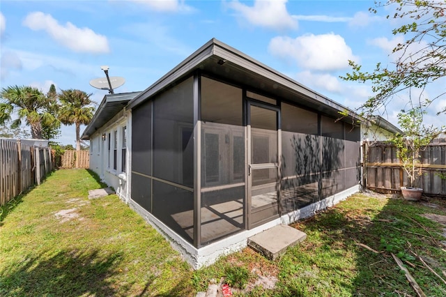 rear view of house with a sunroom and a lawn