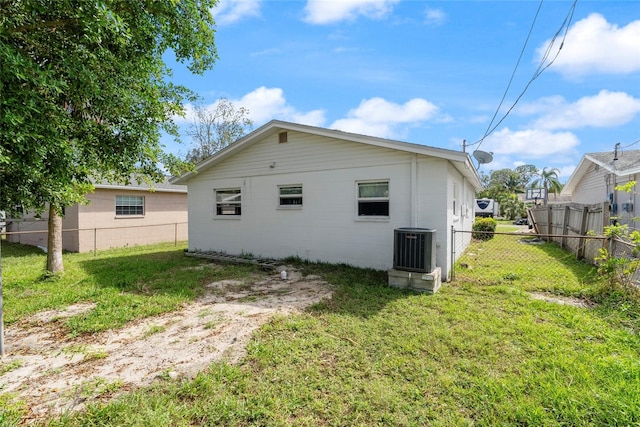 back of property featuring a yard and central AC unit