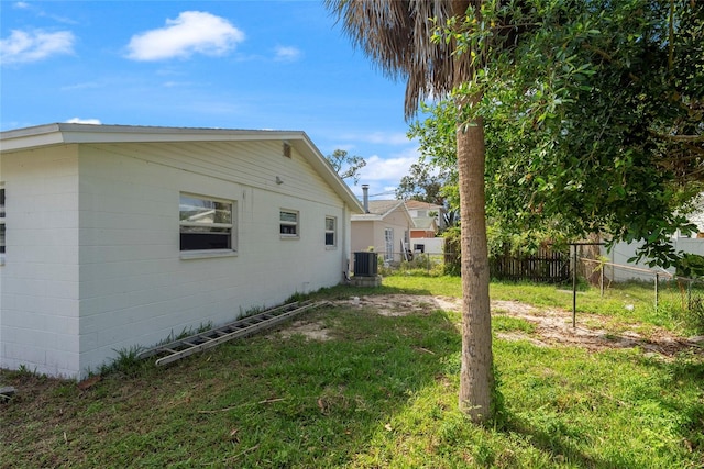 view of side of property featuring a yard and central AC unit