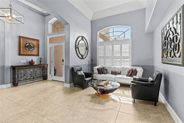 tiled living room featuring high vaulted ceiling and an inviting chandelier