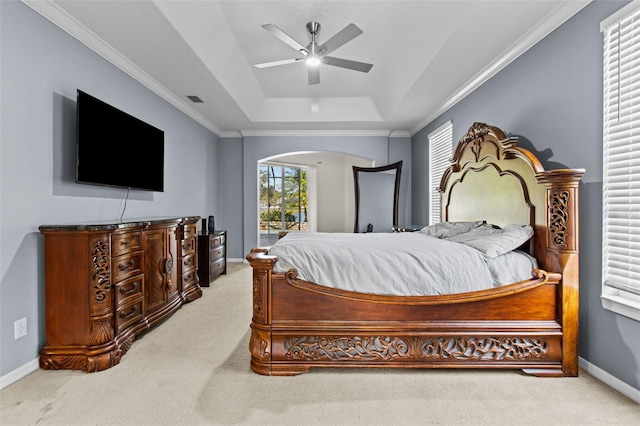 bedroom featuring a tray ceiling, ornamental molding, carpet, and ceiling fan