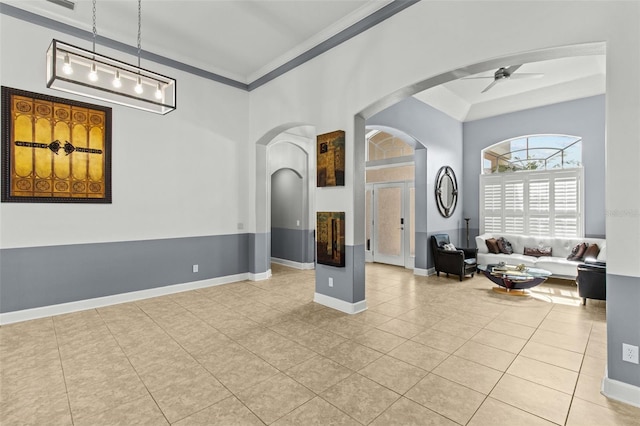 interior space with ceiling fan, crown molding, and light tile patterned floors