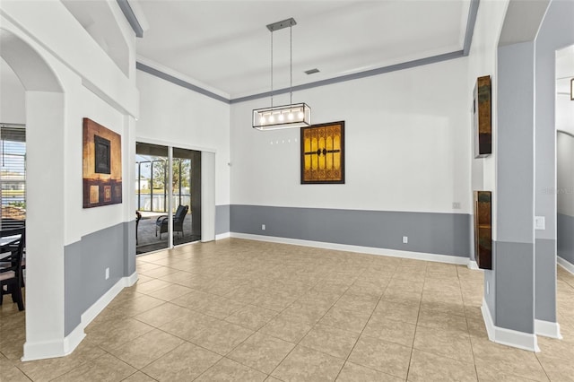 tiled spare room featuring crown molding