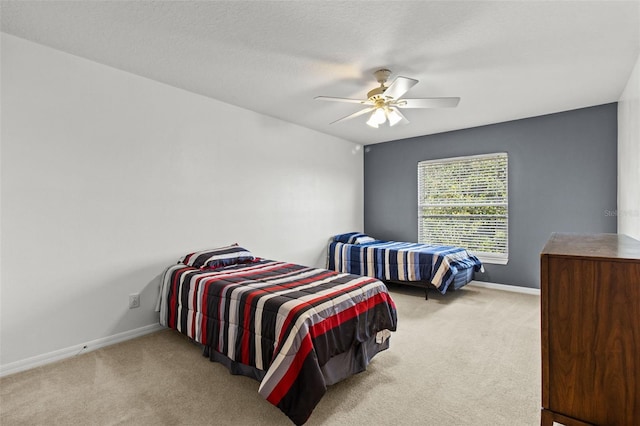 carpeted bedroom with ceiling fan and a textured ceiling