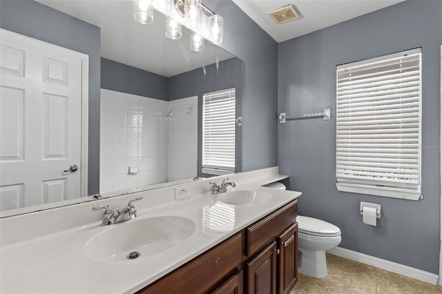 bathroom with tile patterned flooring, vanity, toilet, and a shower