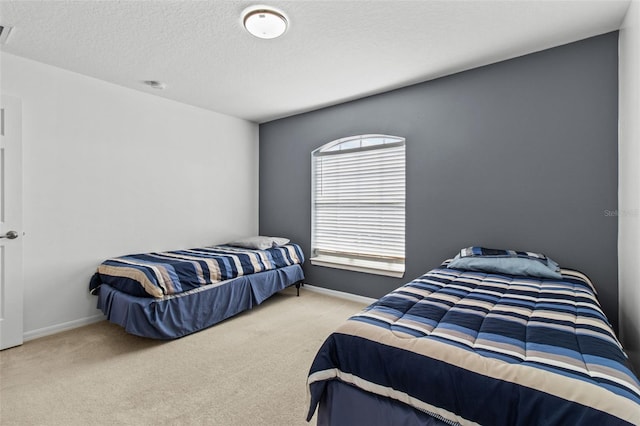 bedroom with a textured ceiling and light carpet