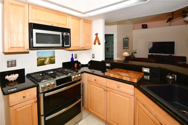 kitchen featuring light brown cabinetry and appliances with stainless steel finishes