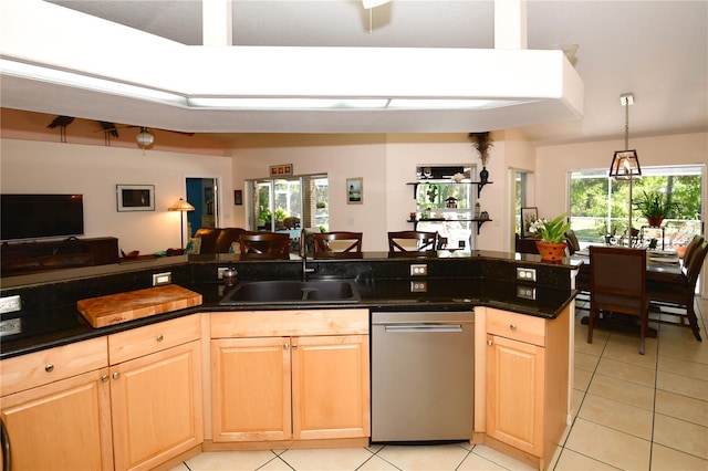 kitchen with stainless steel dishwasher, sink, light tile patterned floors, and a healthy amount of sunlight