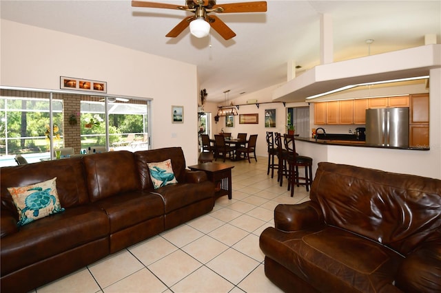 tiled living room with ceiling fan, sink, and vaulted ceiling