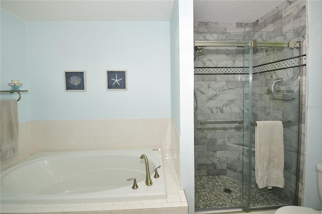 bathroom featuring toilet, shower with separate bathtub, and a textured ceiling