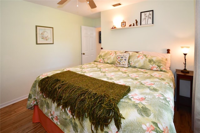 bedroom with dark hardwood / wood-style flooring and ceiling fan