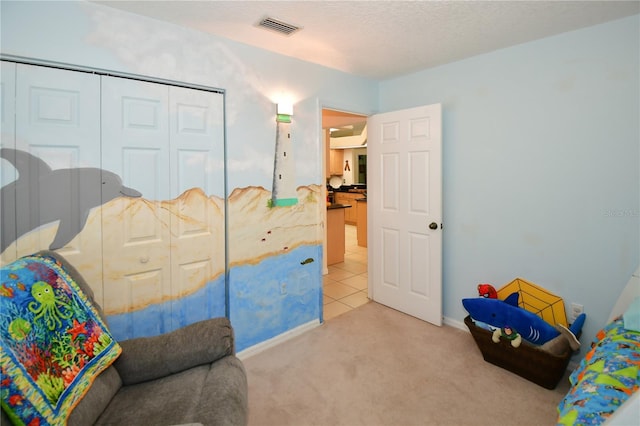 bedroom featuring light carpet, a closet, and a textured ceiling