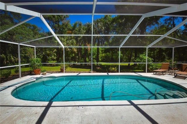 view of swimming pool featuring glass enclosure and a patio area