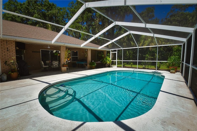 view of swimming pool featuring a patio area and a lanai