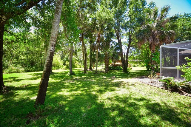 view of yard with glass enclosure