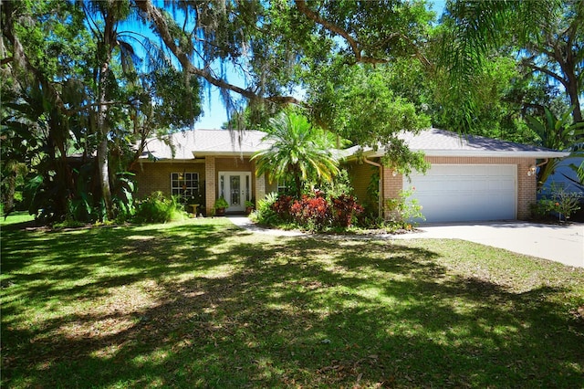 ranch-style home featuring a garage and a front lawn