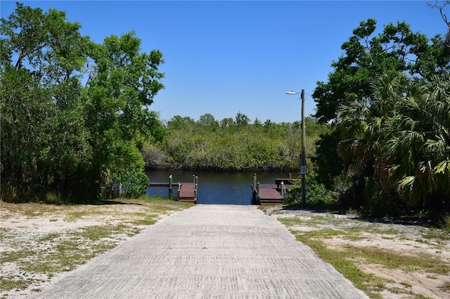 view of front of property with a dock and a water view