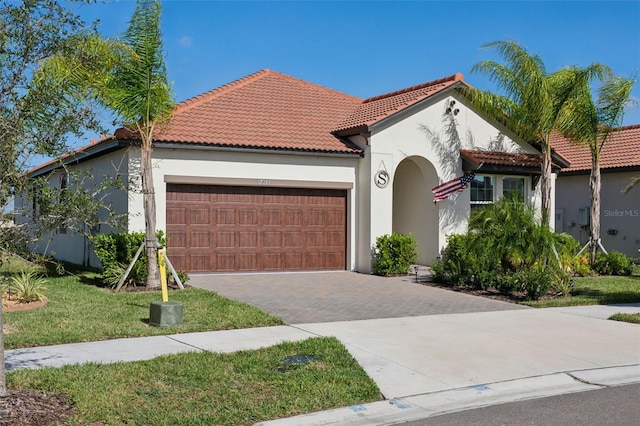 mediterranean / spanish house featuring a front yard and a garage