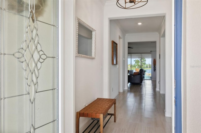 hall featuring crown molding and a chandelier