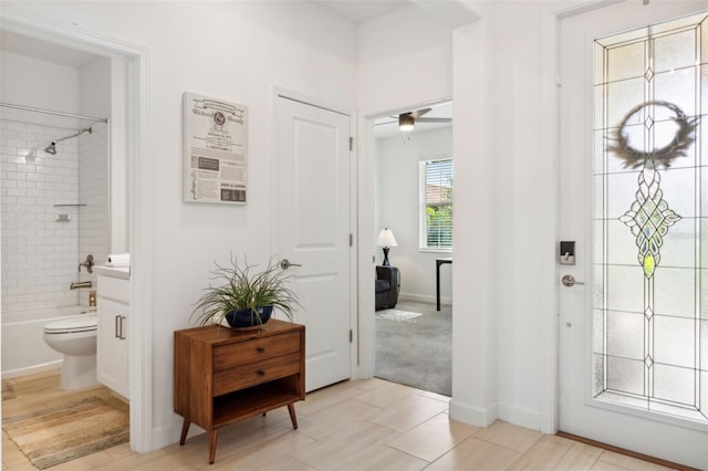 foyer featuring ceiling fan and light tile patterned floors