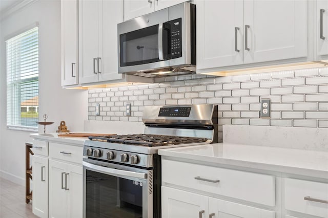 kitchen with white cabinets, decorative backsplash, stainless steel appliances, and light hardwood / wood-style flooring