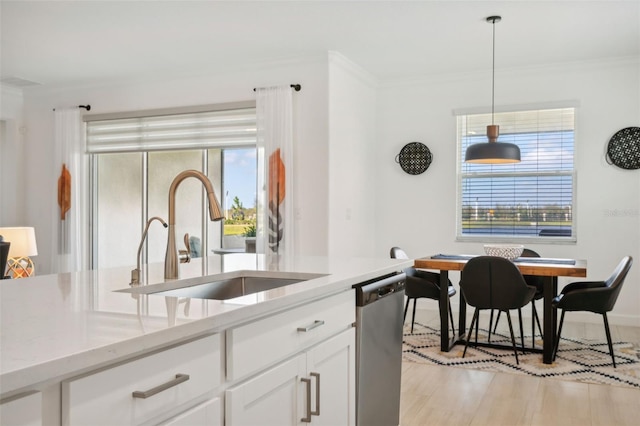 kitchen featuring dishwasher, white cabinets, sink, decorative light fixtures, and light stone counters