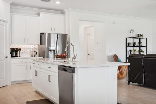 kitchen with white cabinetry, sink, stainless steel appliances, tasteful backsplash, and a center island with sink