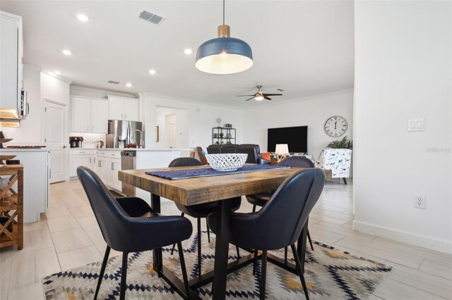 dining area with ceiling fan and ornamental molding