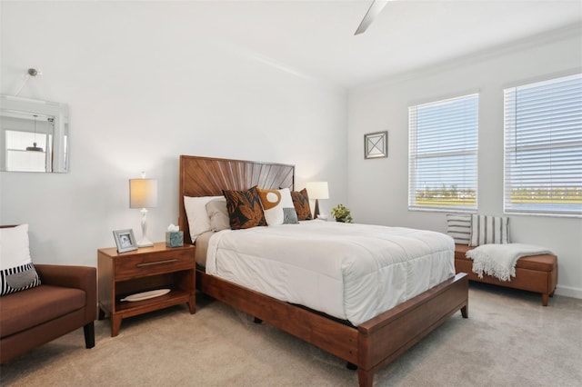 bedroom with light colored carpet, ceiling fan, and ornamental molding