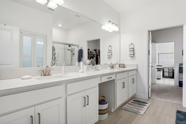 bathroom featuring vanity and a shower with shower door