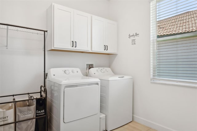 laundry area featuring washer and clothes dryer and cabinets