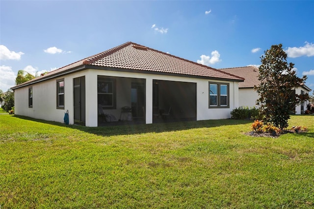 rear view of property featuring a yard and a sunroom