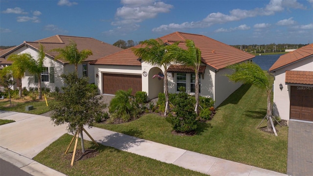 mediterranean / spanish-style house with a front yard and a garage