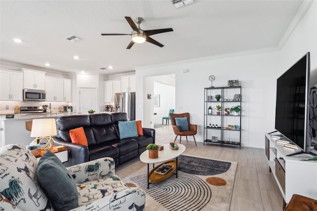 living room featuring ceiling fan and ornamental molding