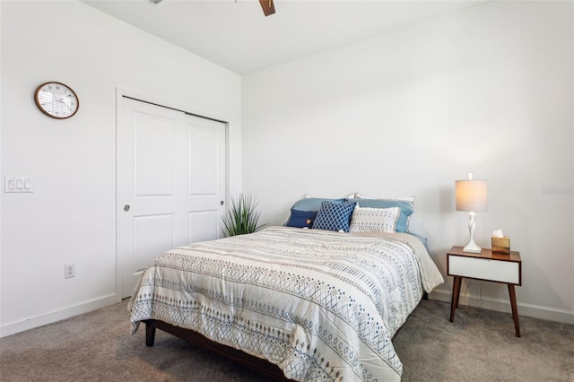 bedroom with ceiling fan, dark carpet, and a closet