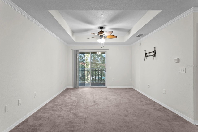 spare room with ceiling fan, crown molding, a raised ceiling, and carpet floors