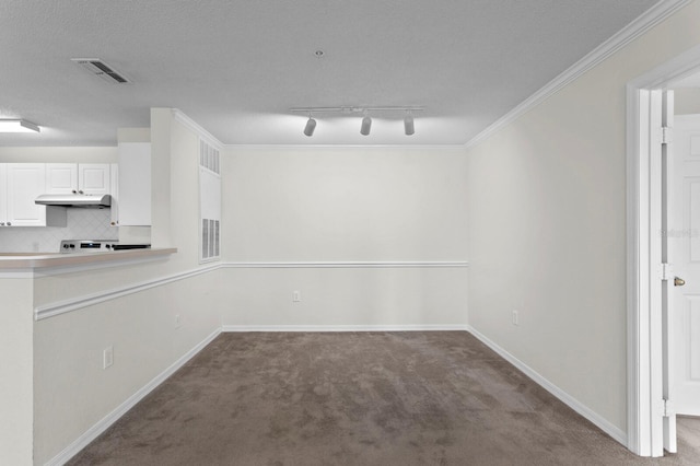 unfurnished dining area featuring a textured ceiling, rail lighting, crown molding, and carpet floors