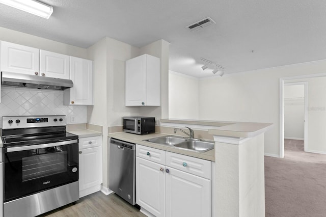 kitchen with stainless steel appliances, sink, kitchen peninsula, light hardwood / wood-style flooring, and white cabinets