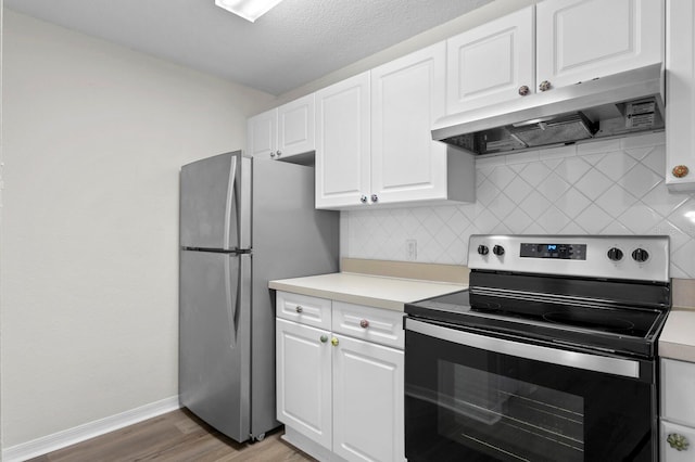 kitchen with dark wood-type flooring, white cabinetry, appliances with stainless steel finishes, and tasteful backsplash