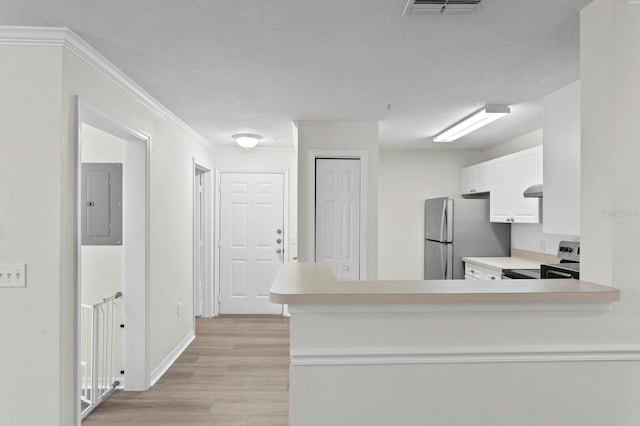 kitchen with stainless steel appliances, light hardwood / wood-style floors, white cabinets, and kitchen peninsula