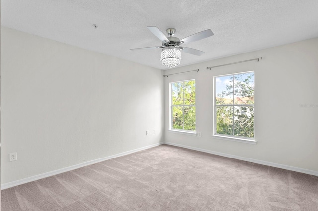 carpeted empty room featuring a textured ceiling and ceiling fan