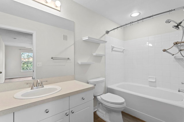 full bathroom with toilet, tiled shower / bath combo, vanity, and hardwood / wood-style floors